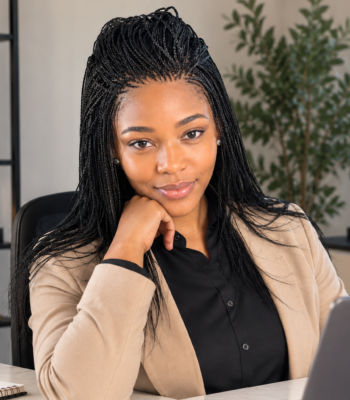 Black professional woman wearing a neat half-up micro-braided wig for an easy low-maintenance workday hairstyle